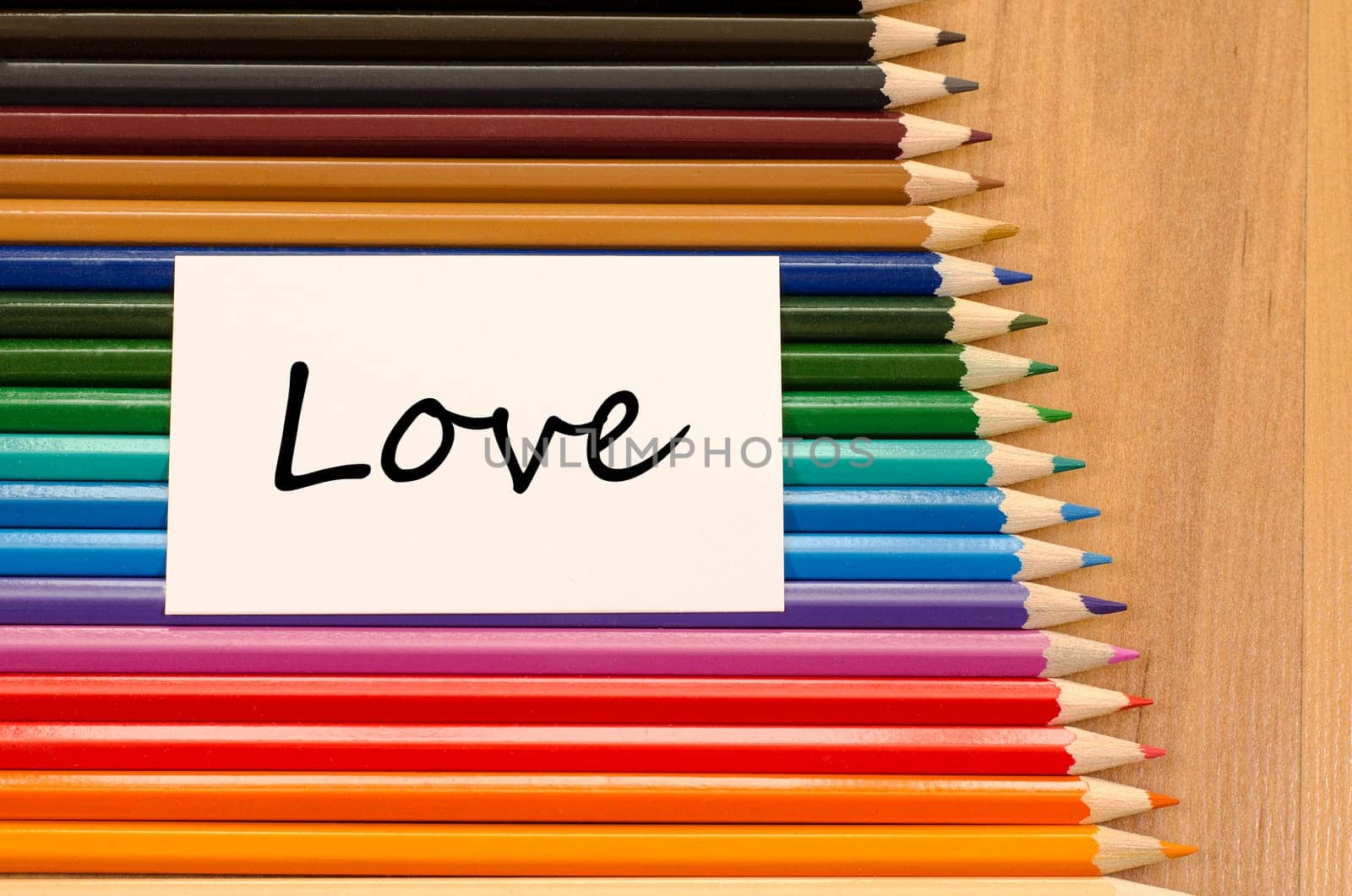 Love text concept and colored pencil on wooden background