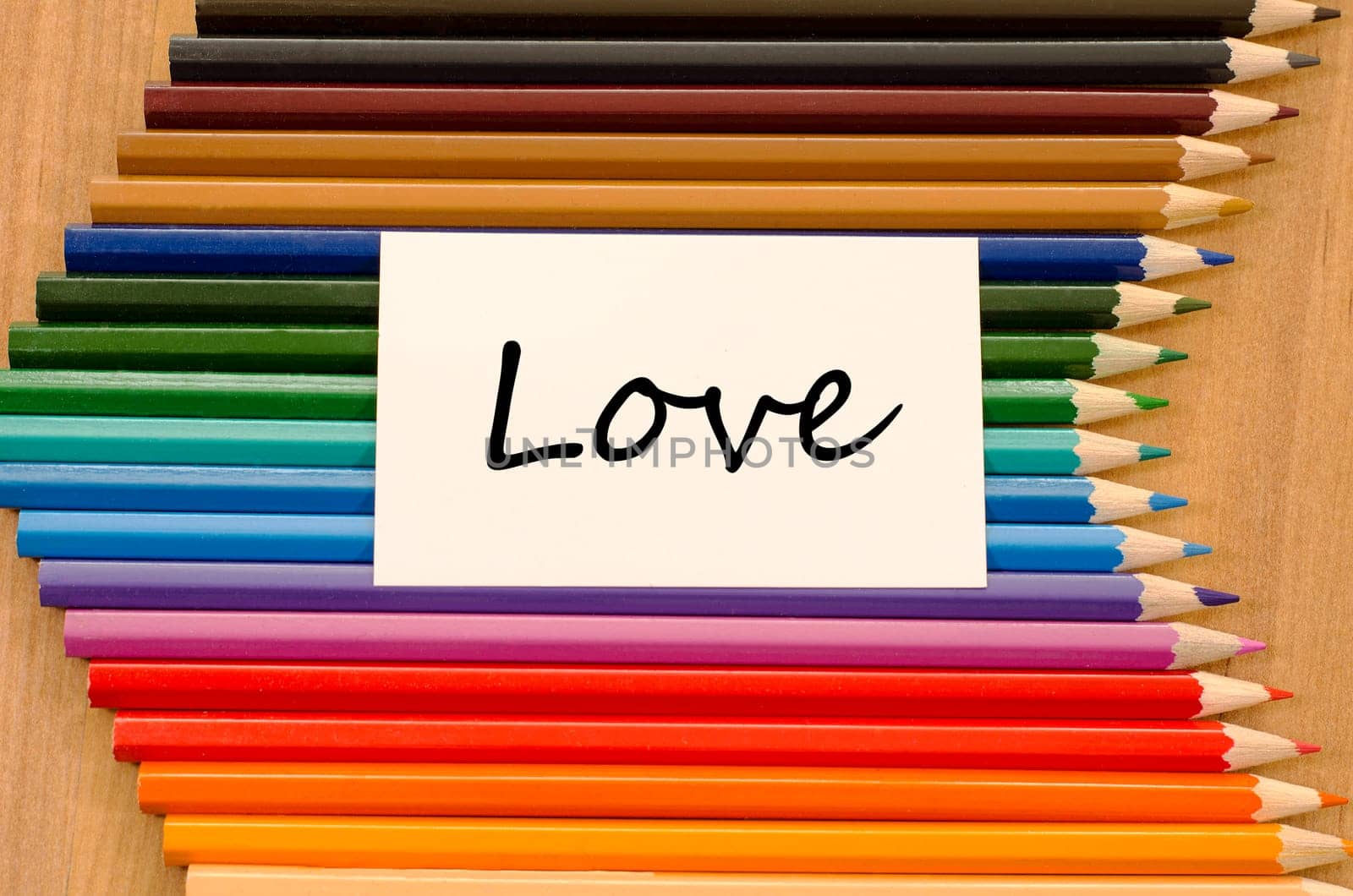 Love text concept and colored pencil on wooden background