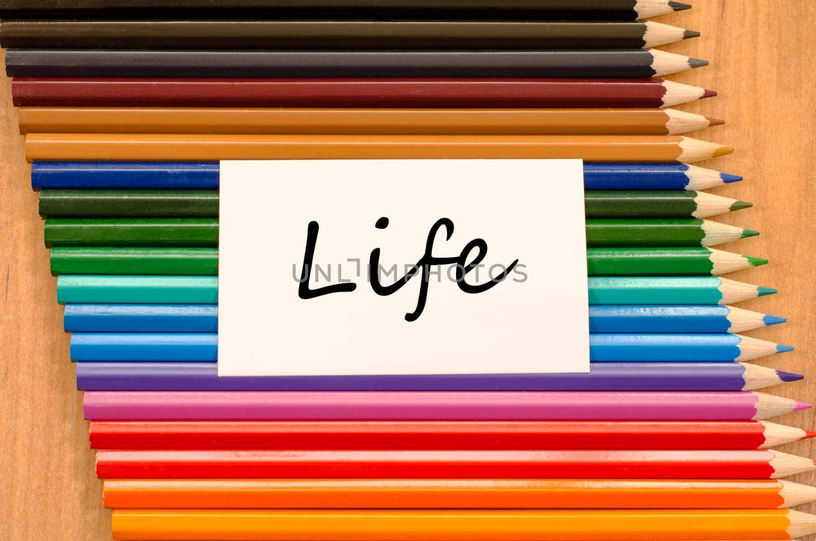 Life text concept and colored pencil on wooden background