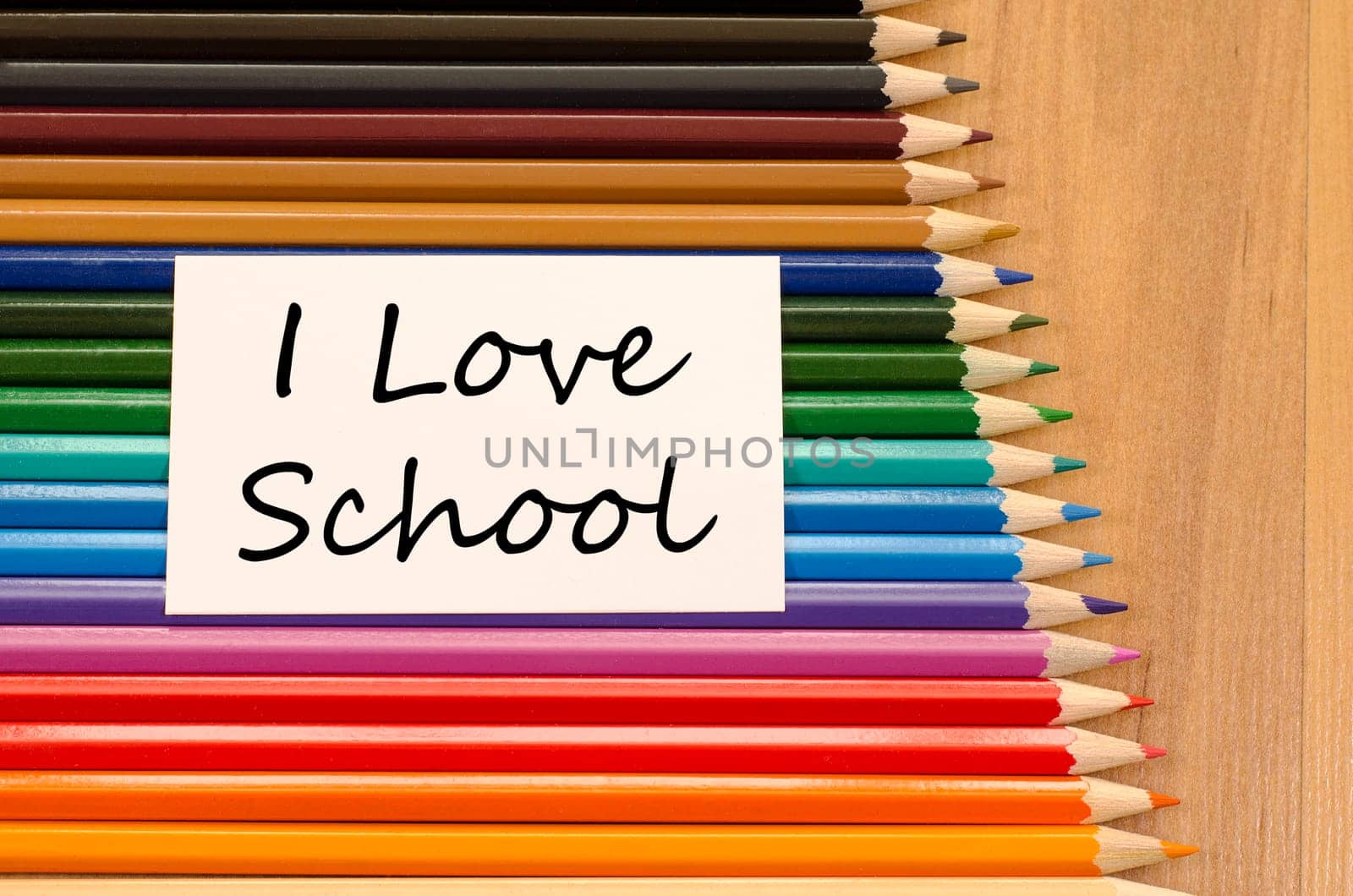 I love school text concept and colored pencil on wooden background