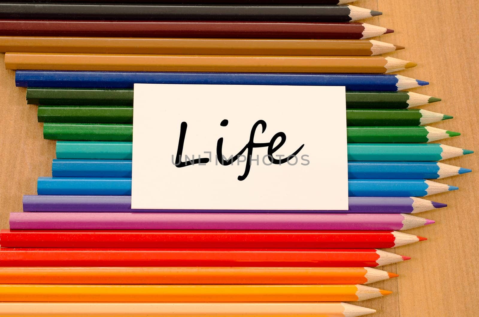 Life text concept and colored pencil on wooden background