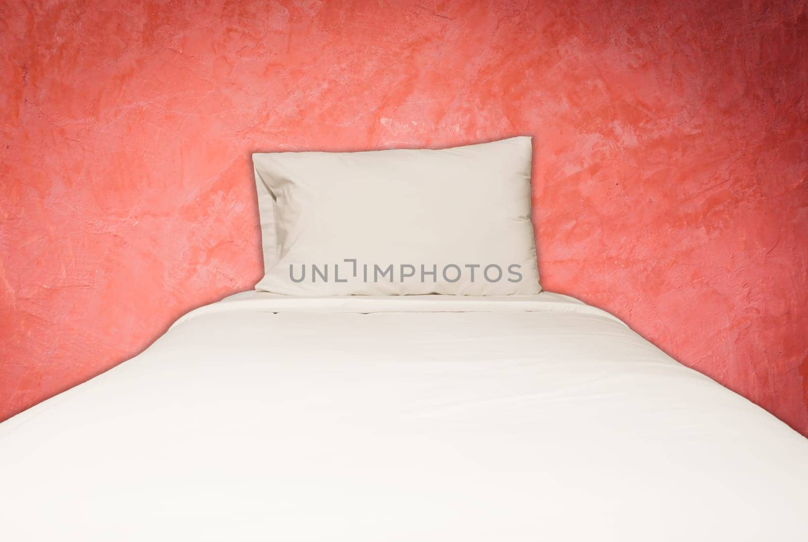 Close up white bedding sheets and pillow on red wall background