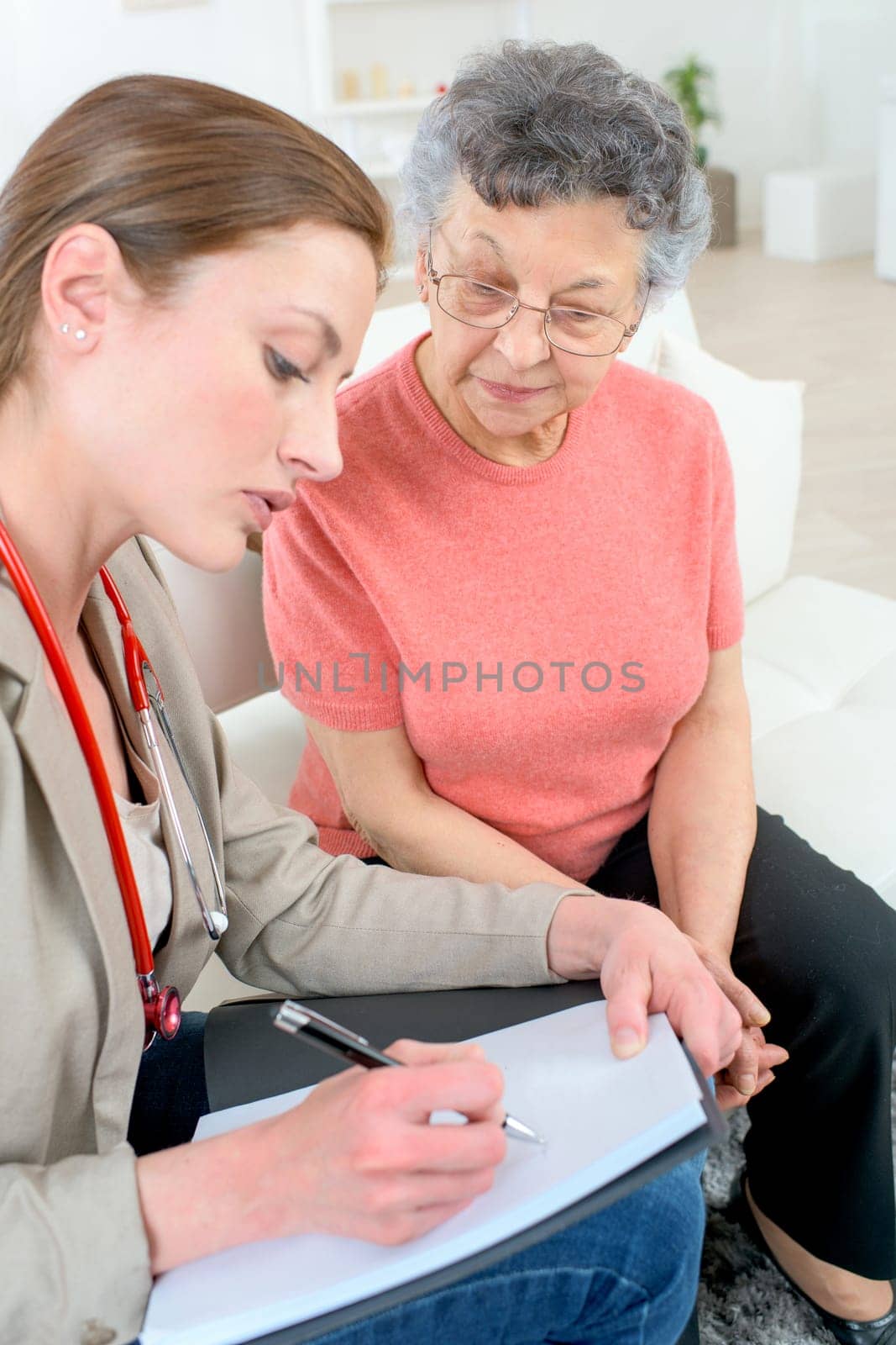 Doctor writing a prescription for a senior patient