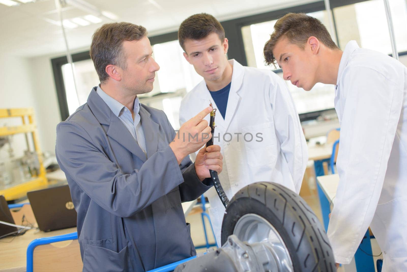Teacher showing students the adapter for inflating tyre