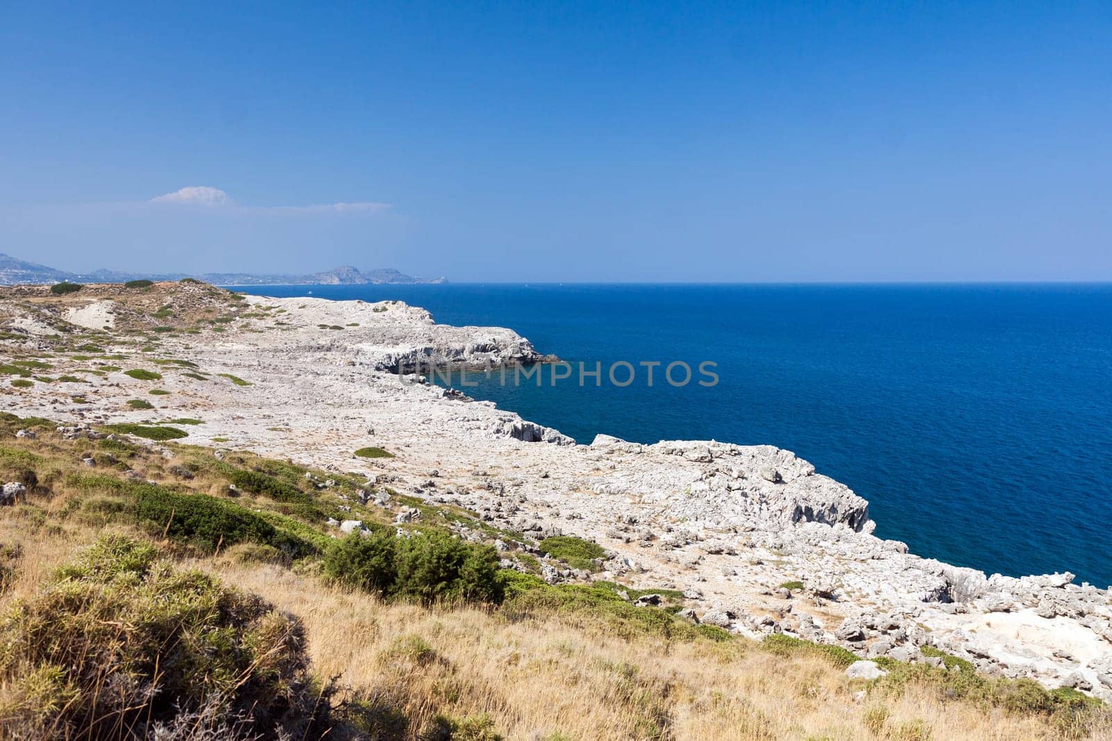 Kolymbia beach with the rocky coast in Greece. Motorboat and speed  in blue sea.