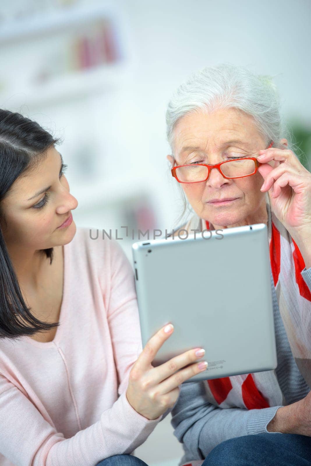 Helping old woman use a tablet computer
