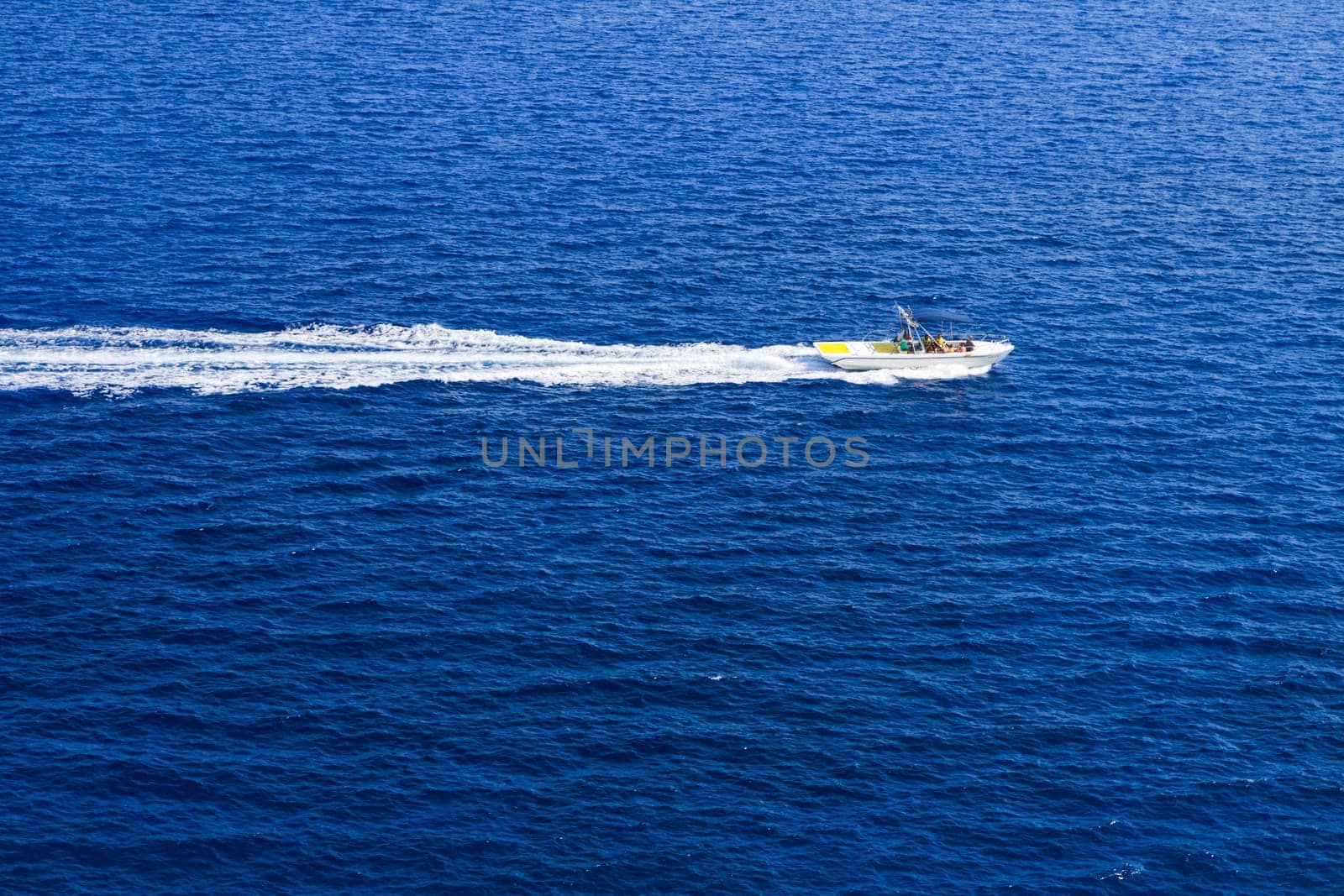 Kolymbia beach with the rocky coast in Greece. Motorboat and speed  in blue sea.