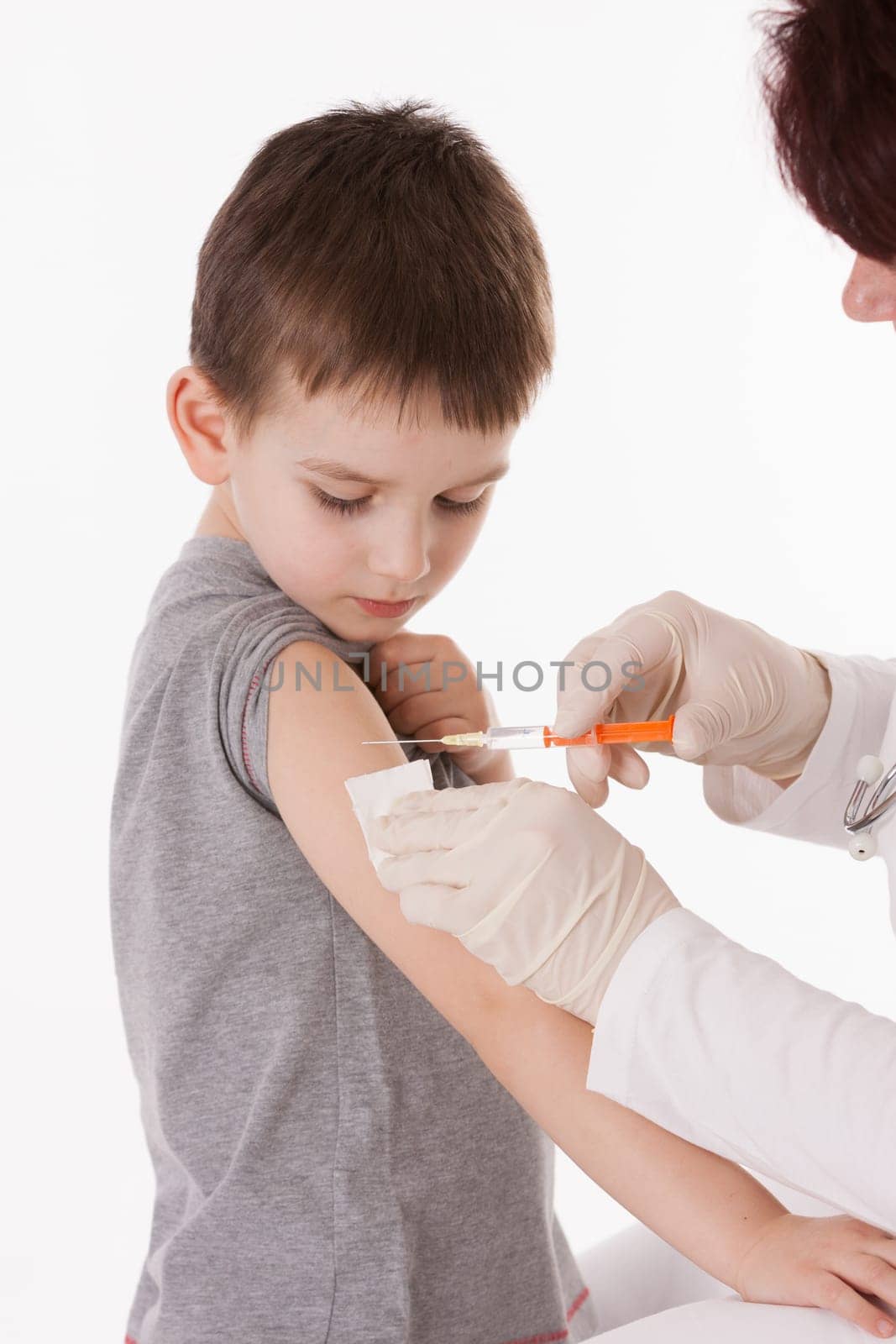 Doctor giving a child injection in arm on isolated image.
