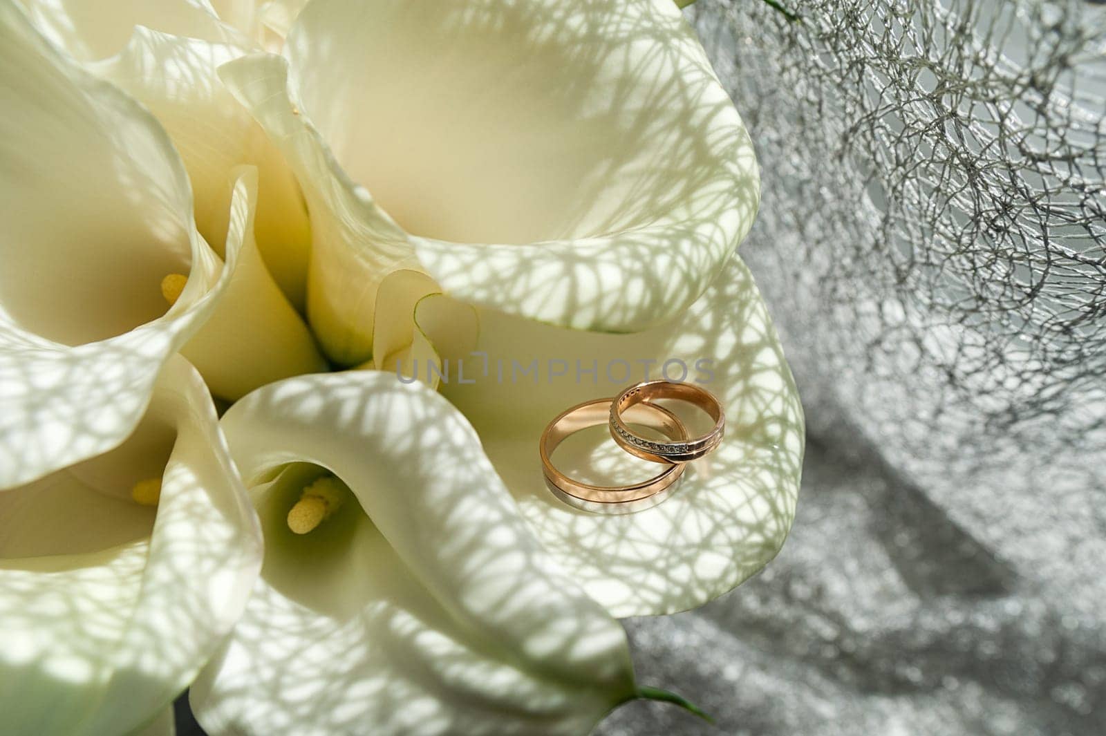 Wedding bouquet of white Calla Marsh Marsh, Bog Arum, Water-Arum, Araceae family. the light of the morning sun, the newlyweds rings