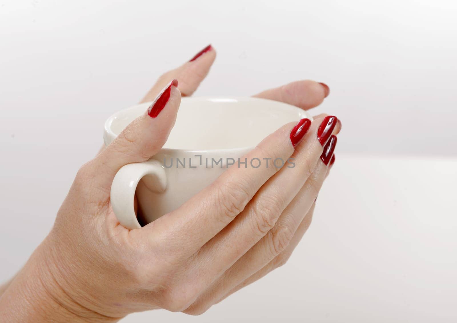 close-up of the hands of a woman with a tea cup