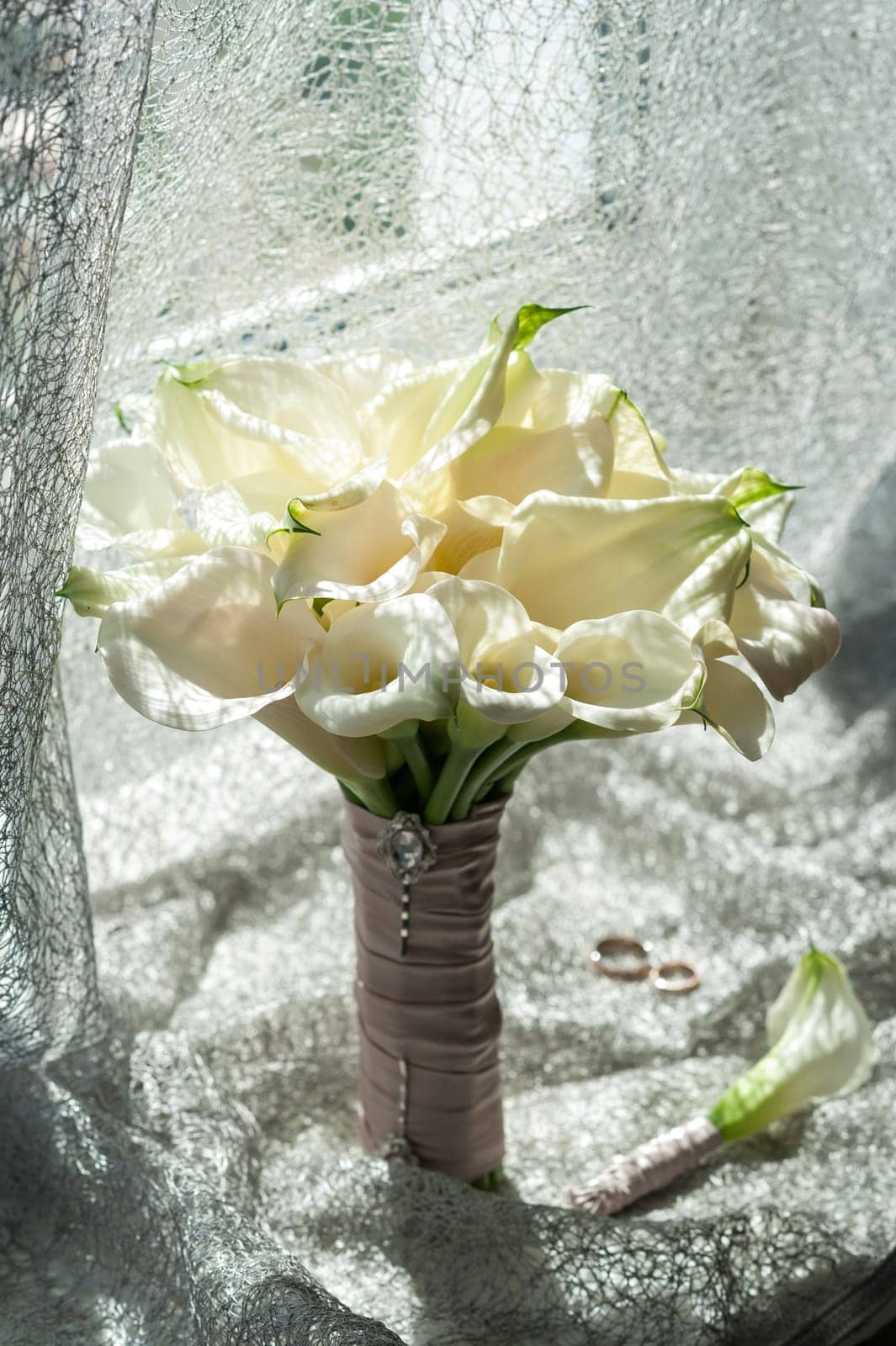 Wedding bouquet of white Calla Marsh Marsh, Bog Arum, Water-Arum, Araceae family. the light of the morning sun, the newlyweds rings