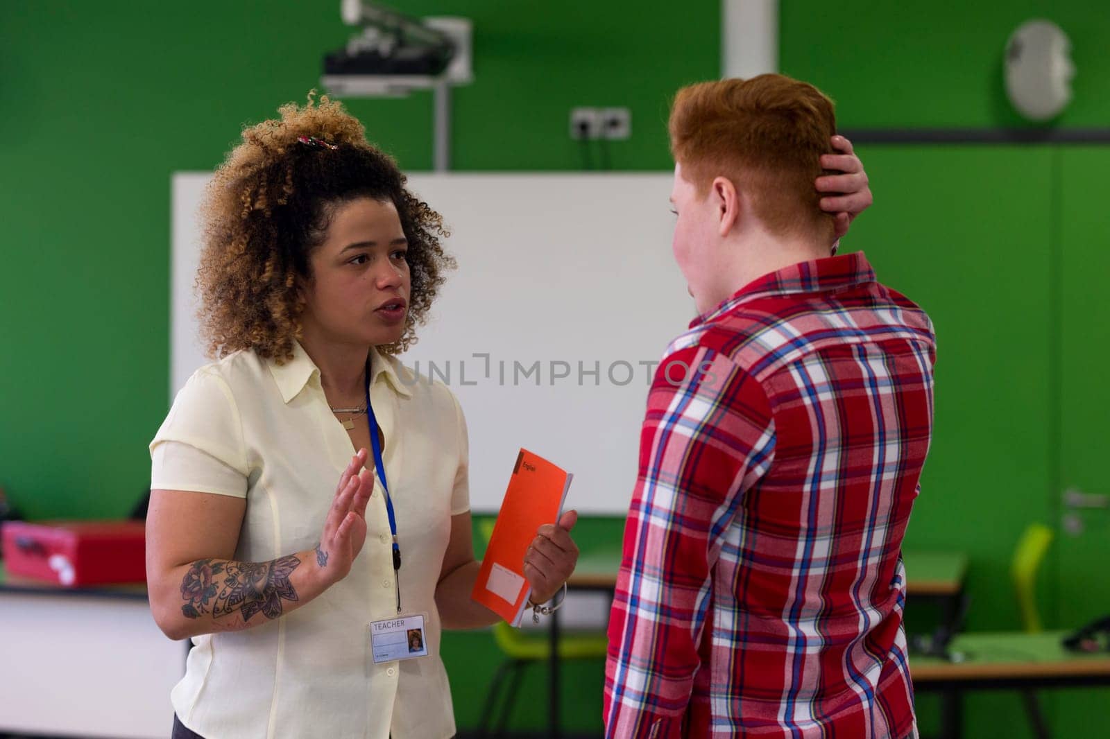 Teenage student being told off by his English teacher at school.