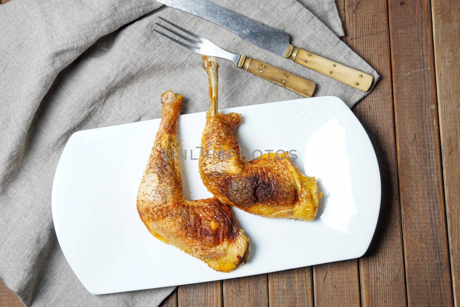 two golden roasted chicken drumstick served on white plate