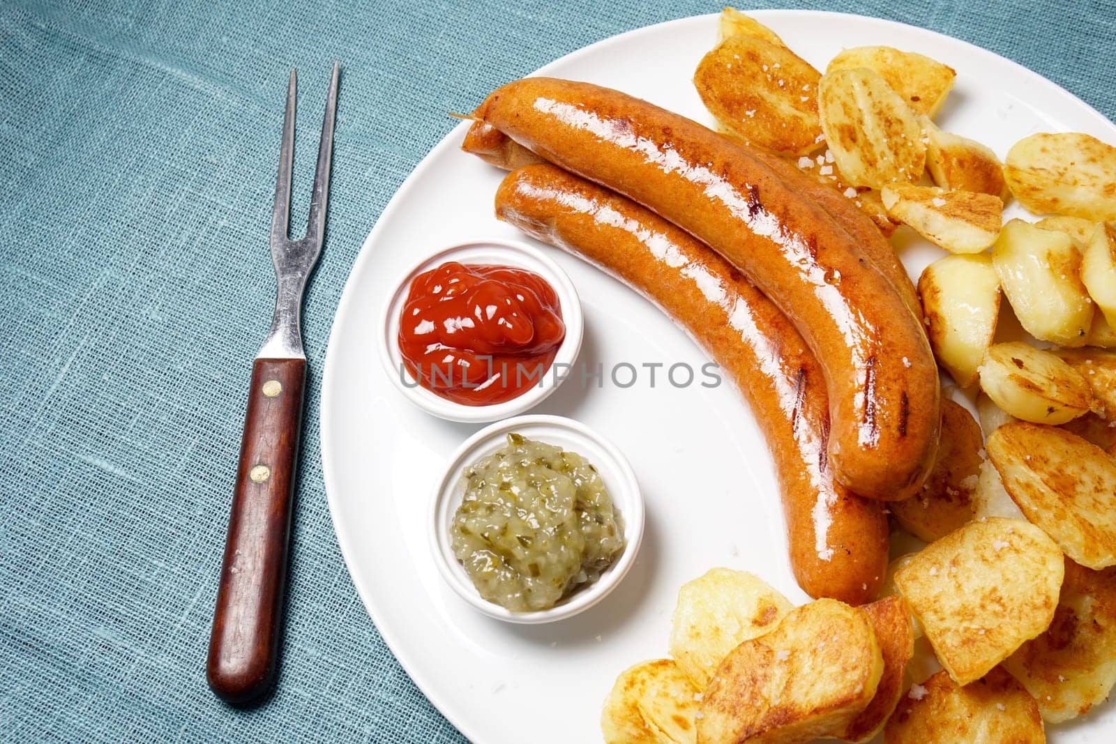 grilled sausages with roasted potatoes, ketchup and cucumber relish