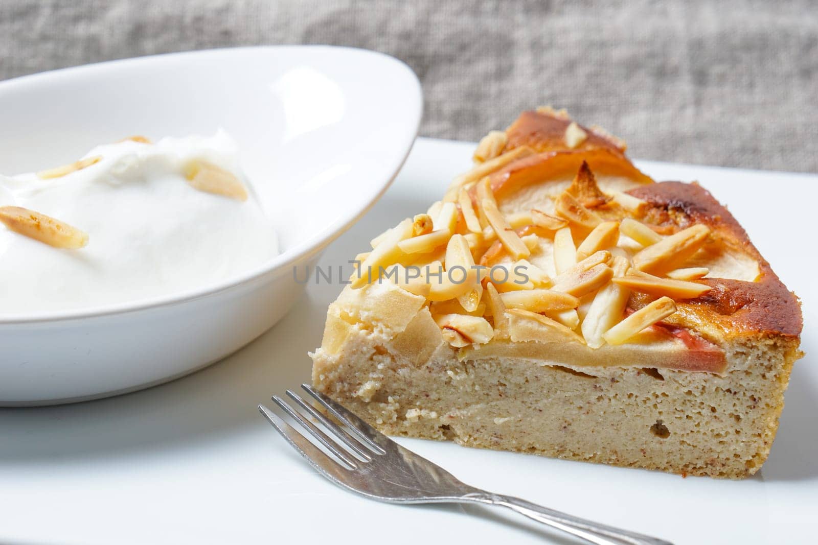 Apple tart. Pie with almonds and sour cream served on a white plate