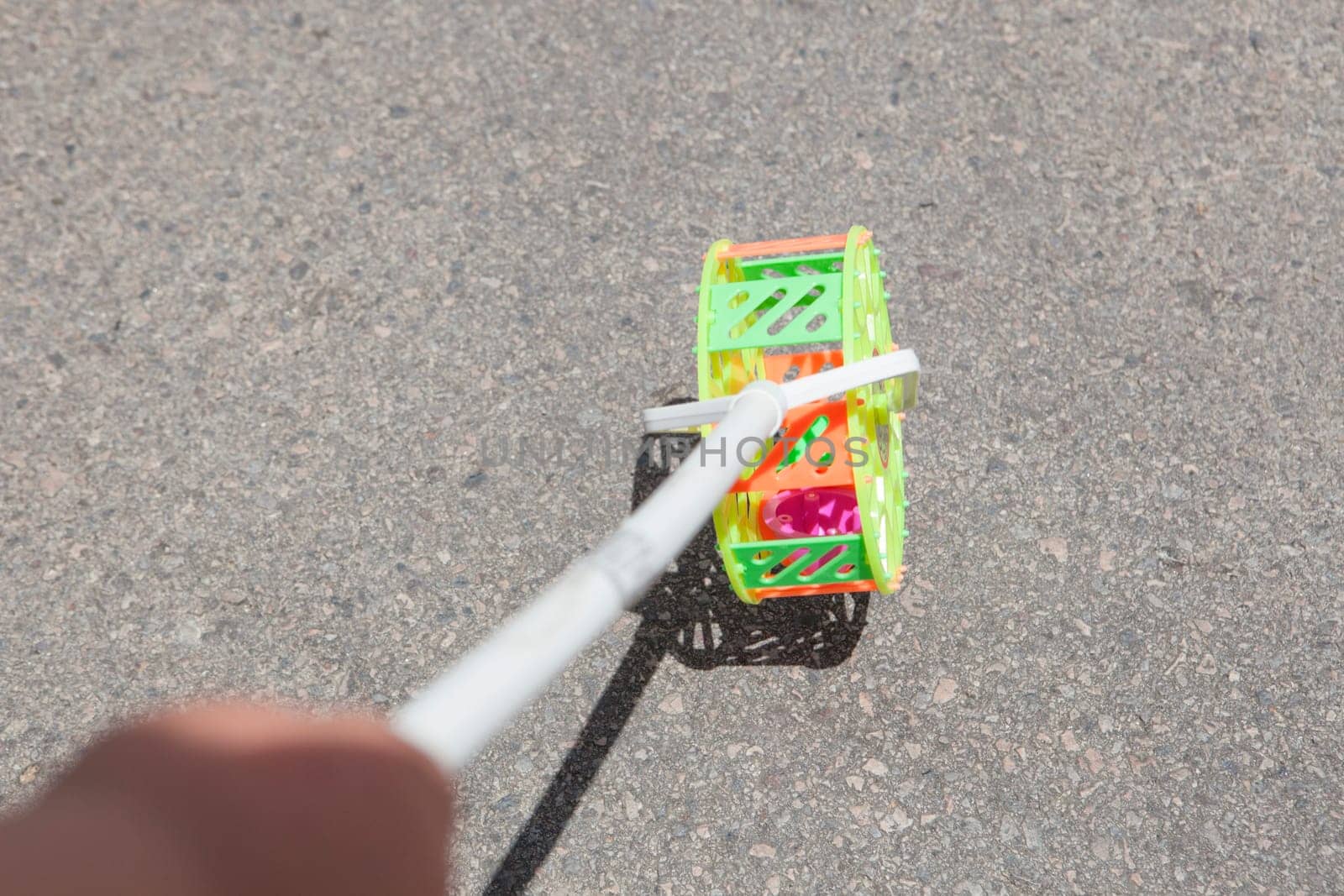 Child with traditional roadrunner wheel toy on street