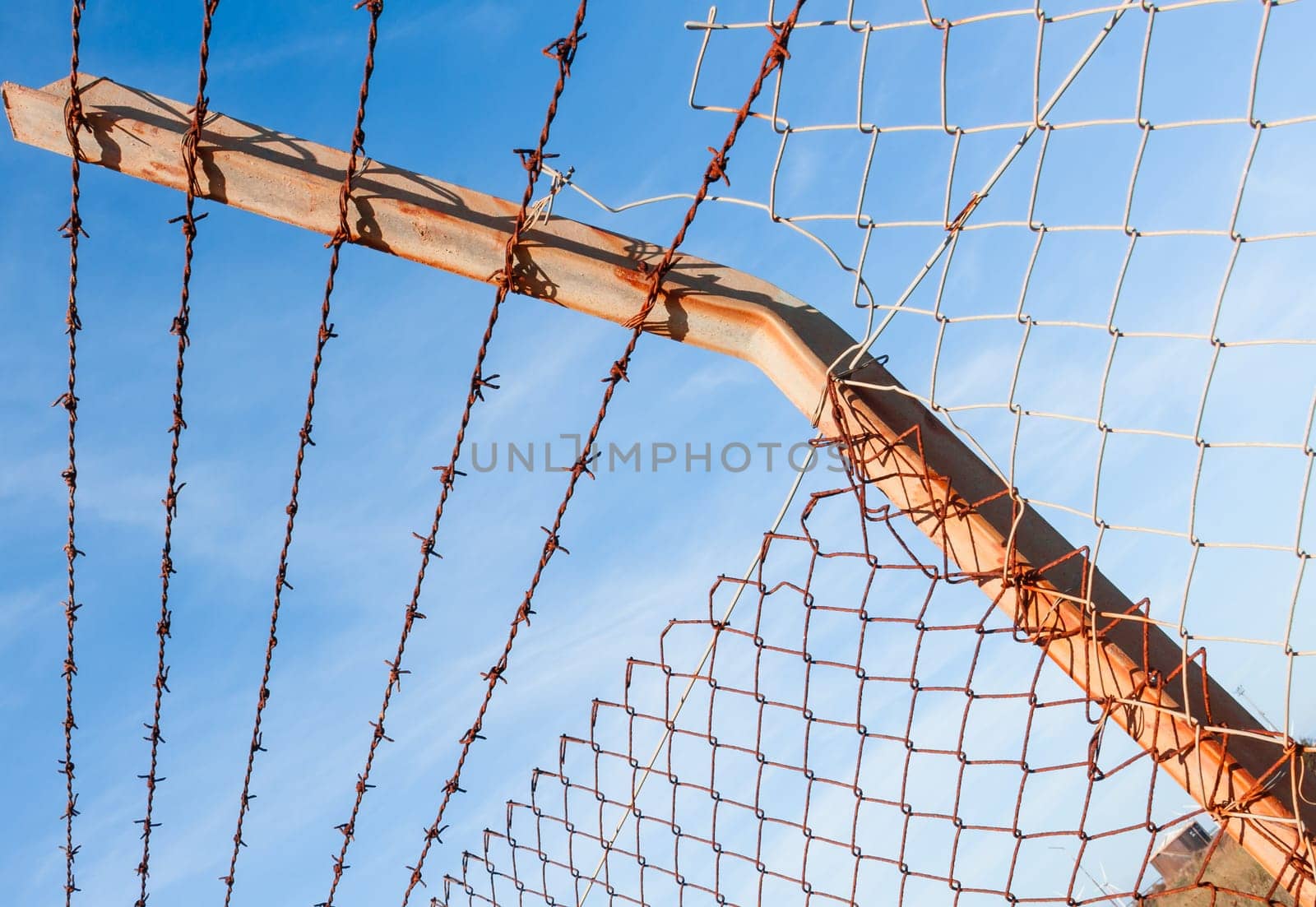 Rusty barbed wire with blue sky