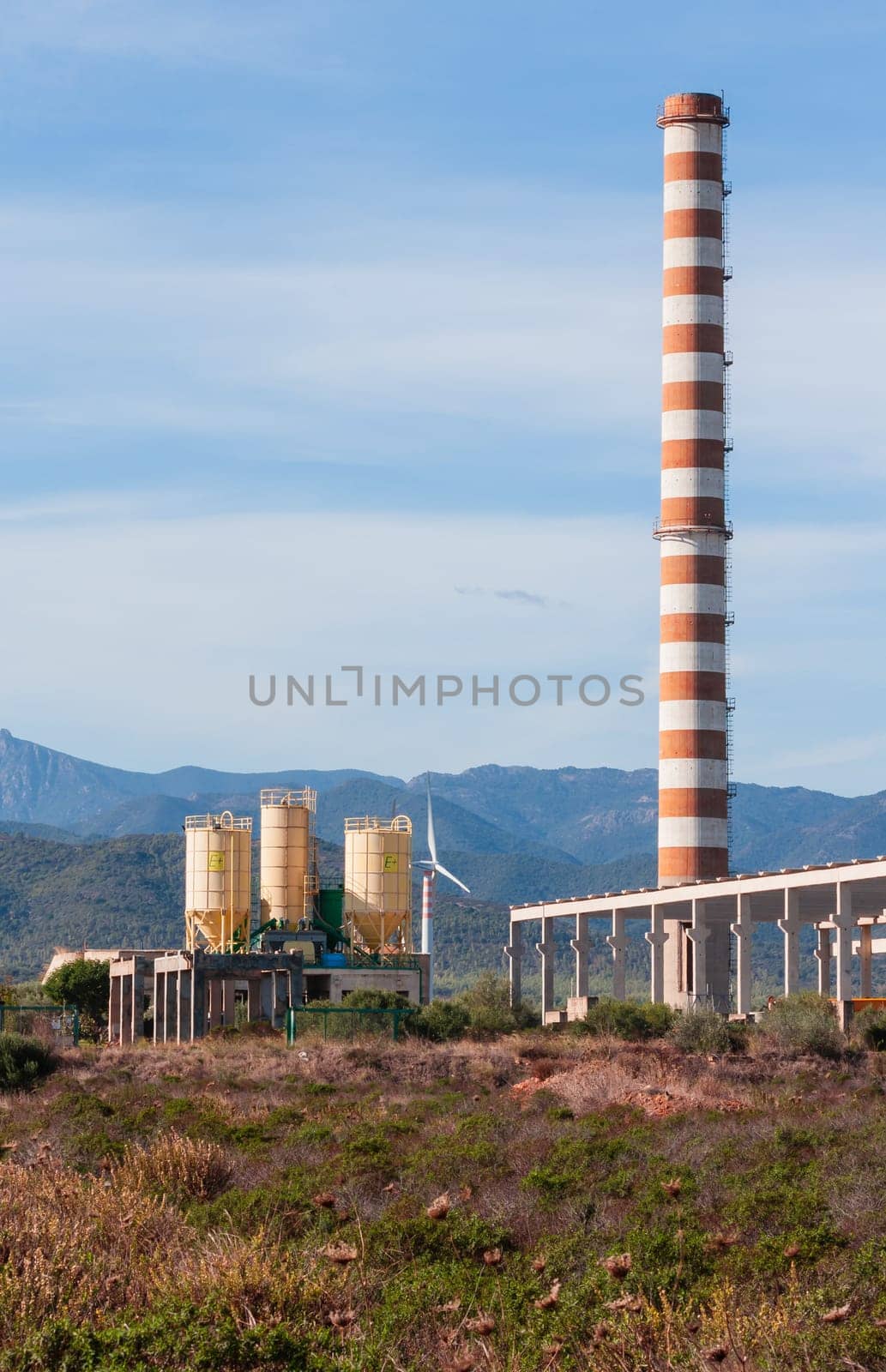 red and white chimney with industrial building