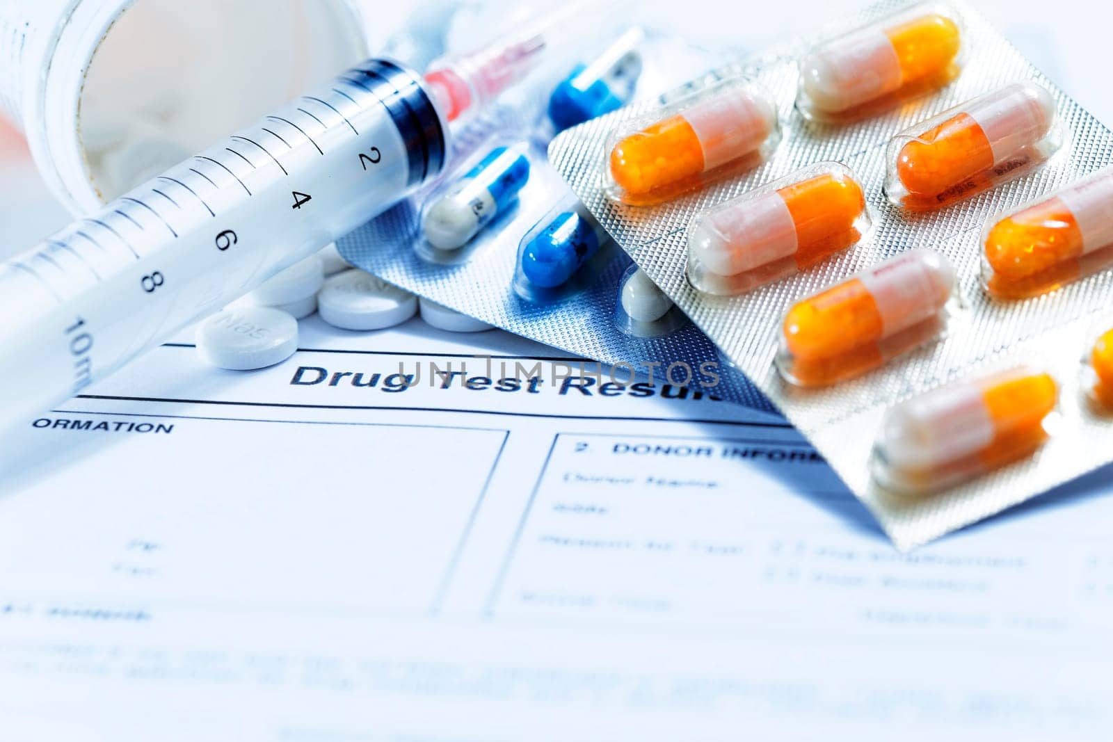 Syringe with glass vials and medications pills drug on white