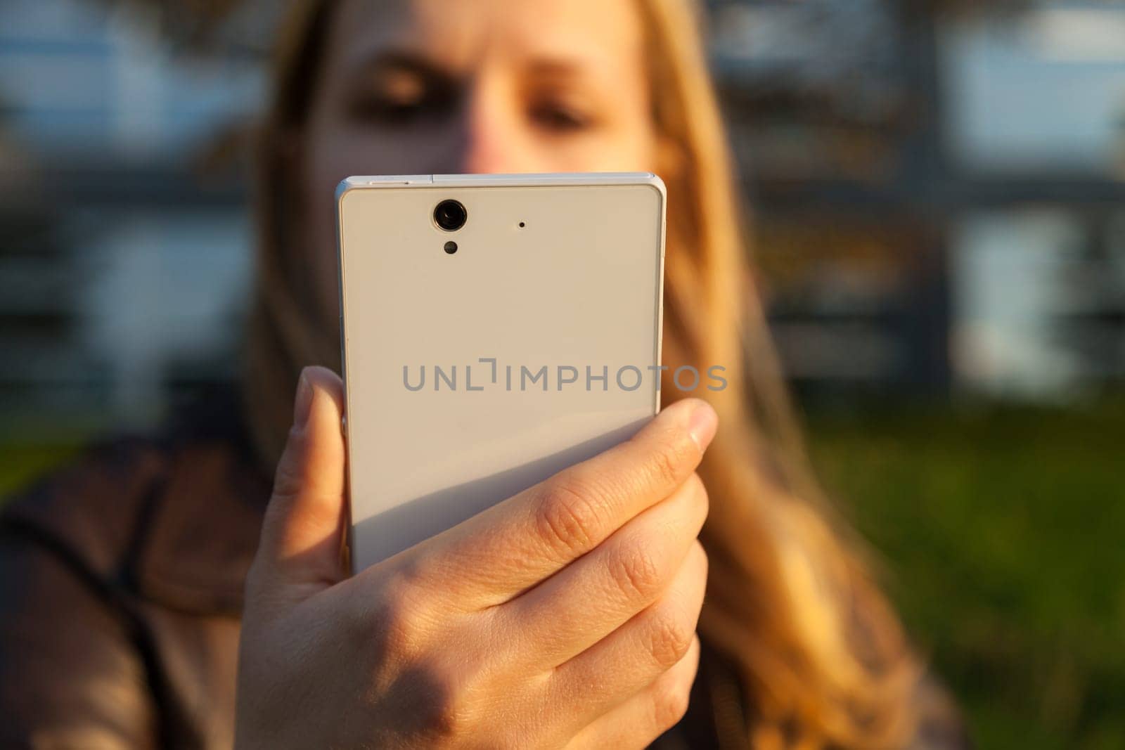 woman with white smartphone in sunlight