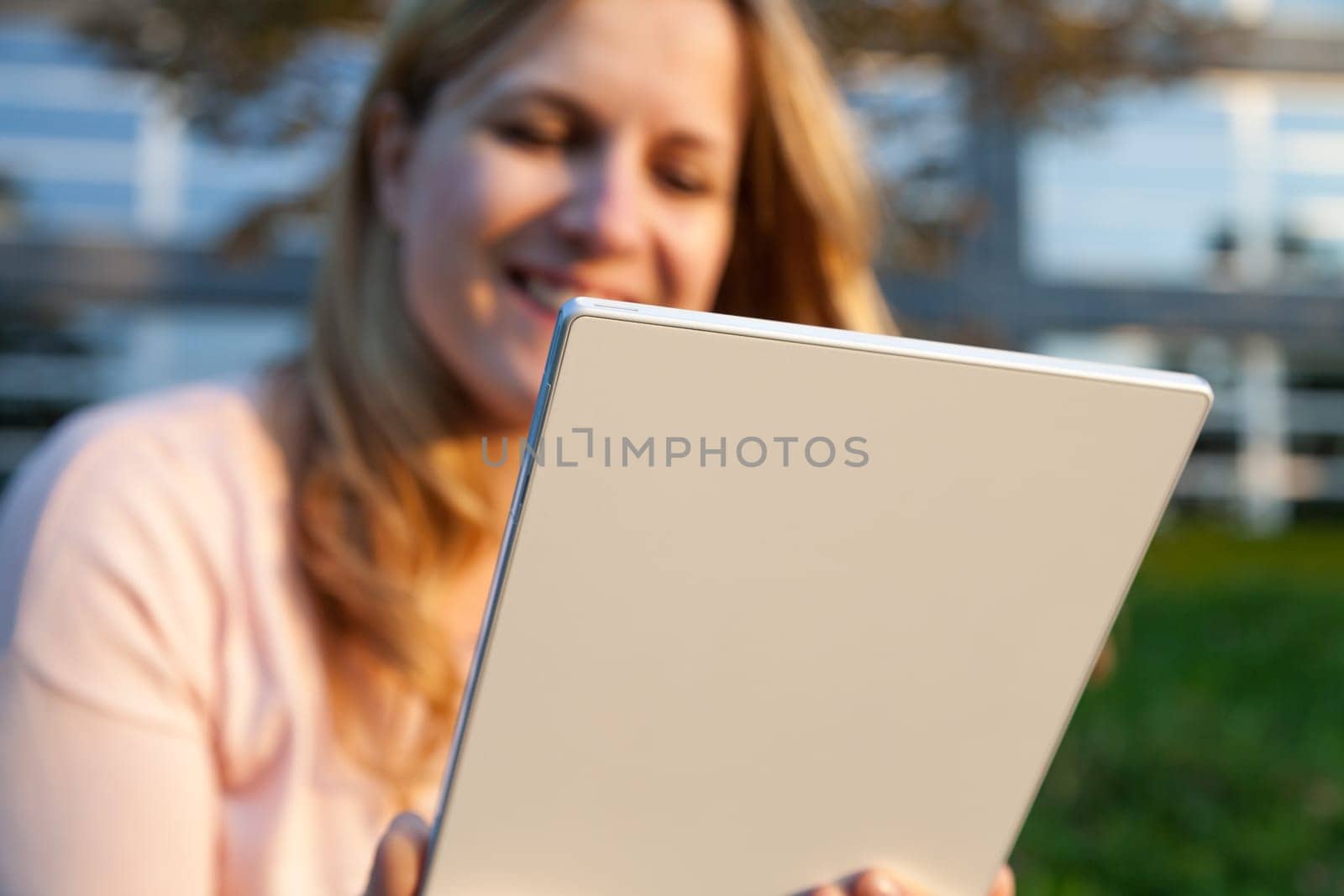 smiling woman with tablet in sunlight