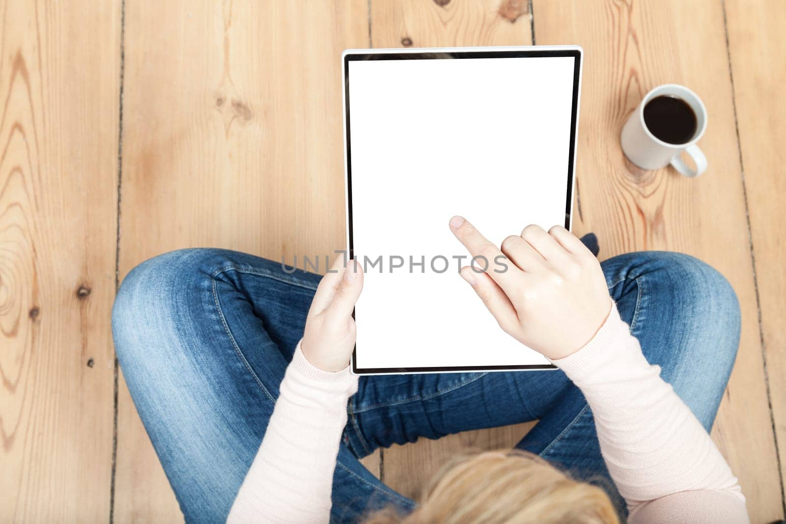 woman holding a tablet on wooden floor