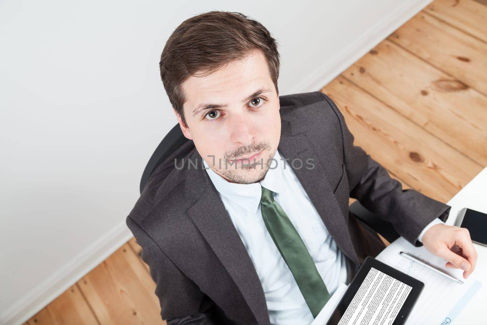 businessman in office with tablet on desk