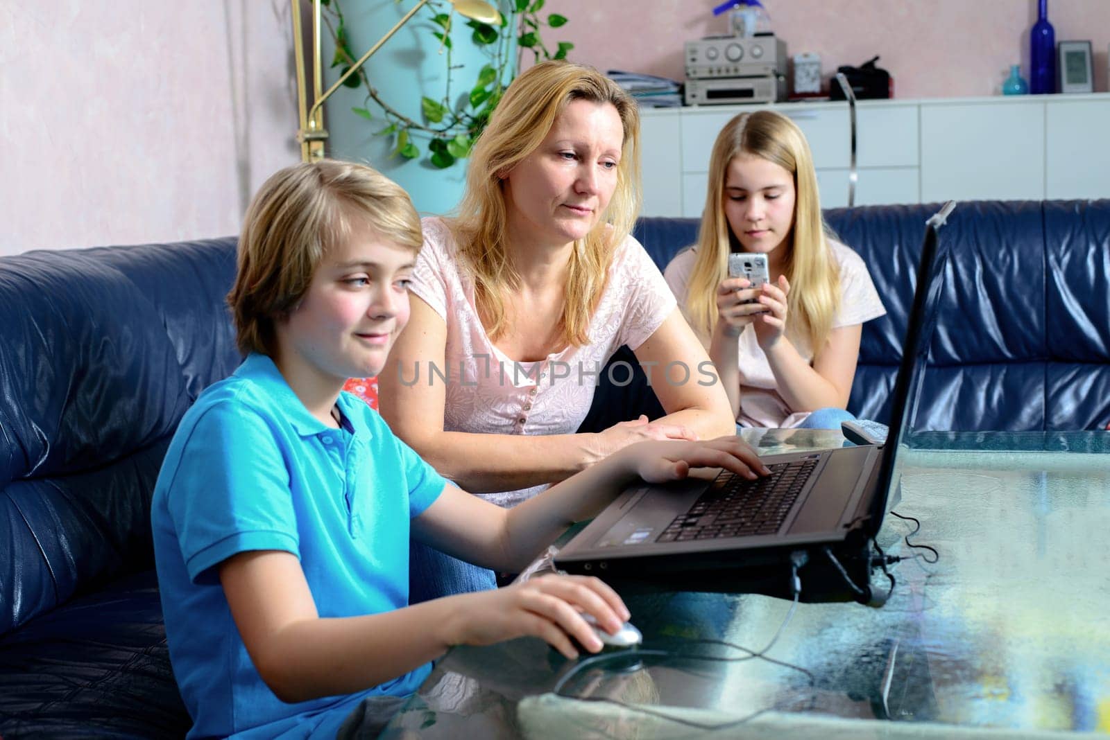 blond mother and her children using computer together