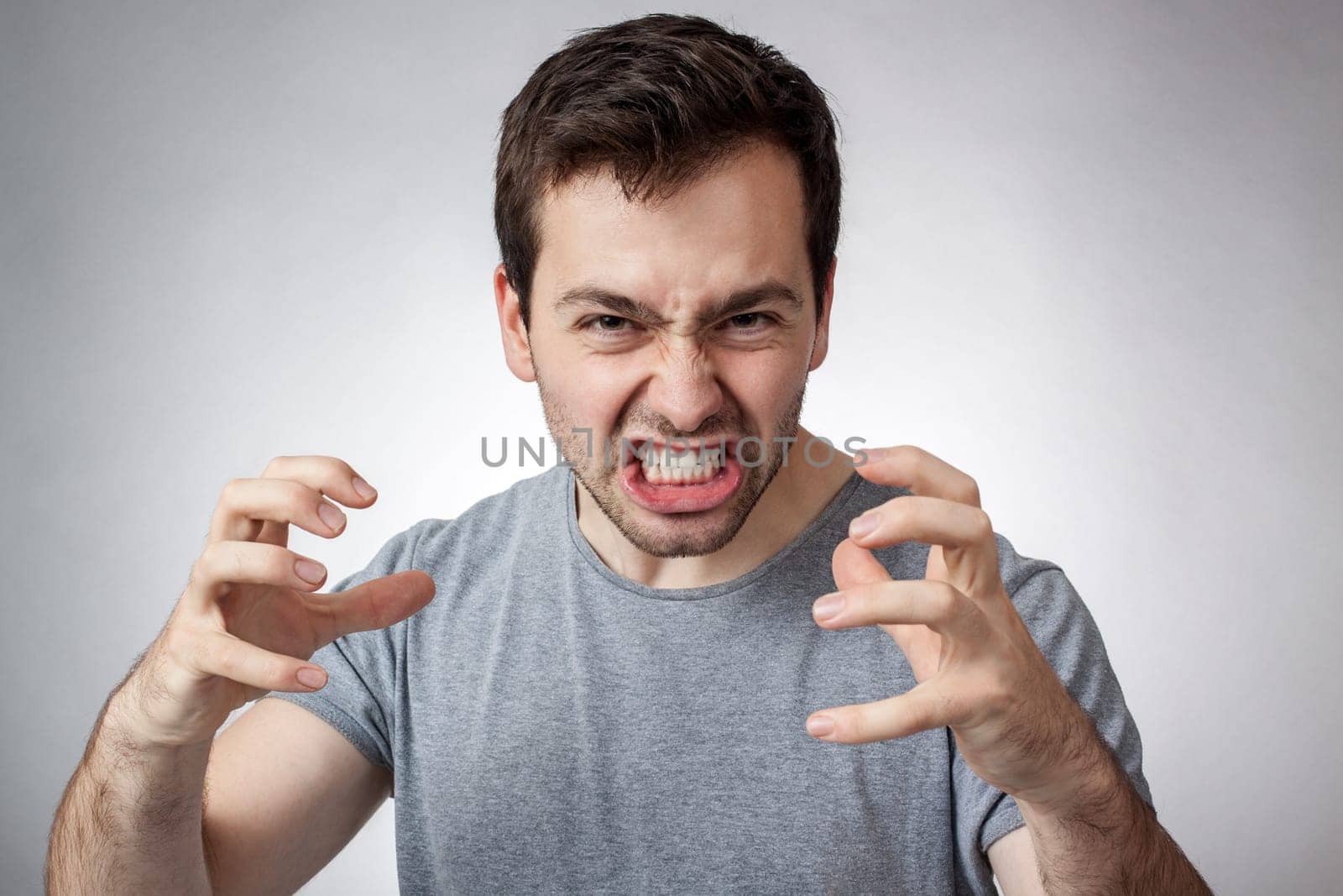 Angry young man clenching his teeth ready to pounce