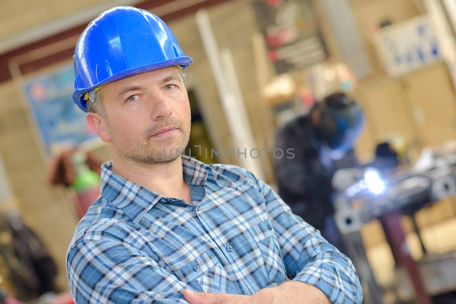 Portrait of man wearing hardhat, arms crossed