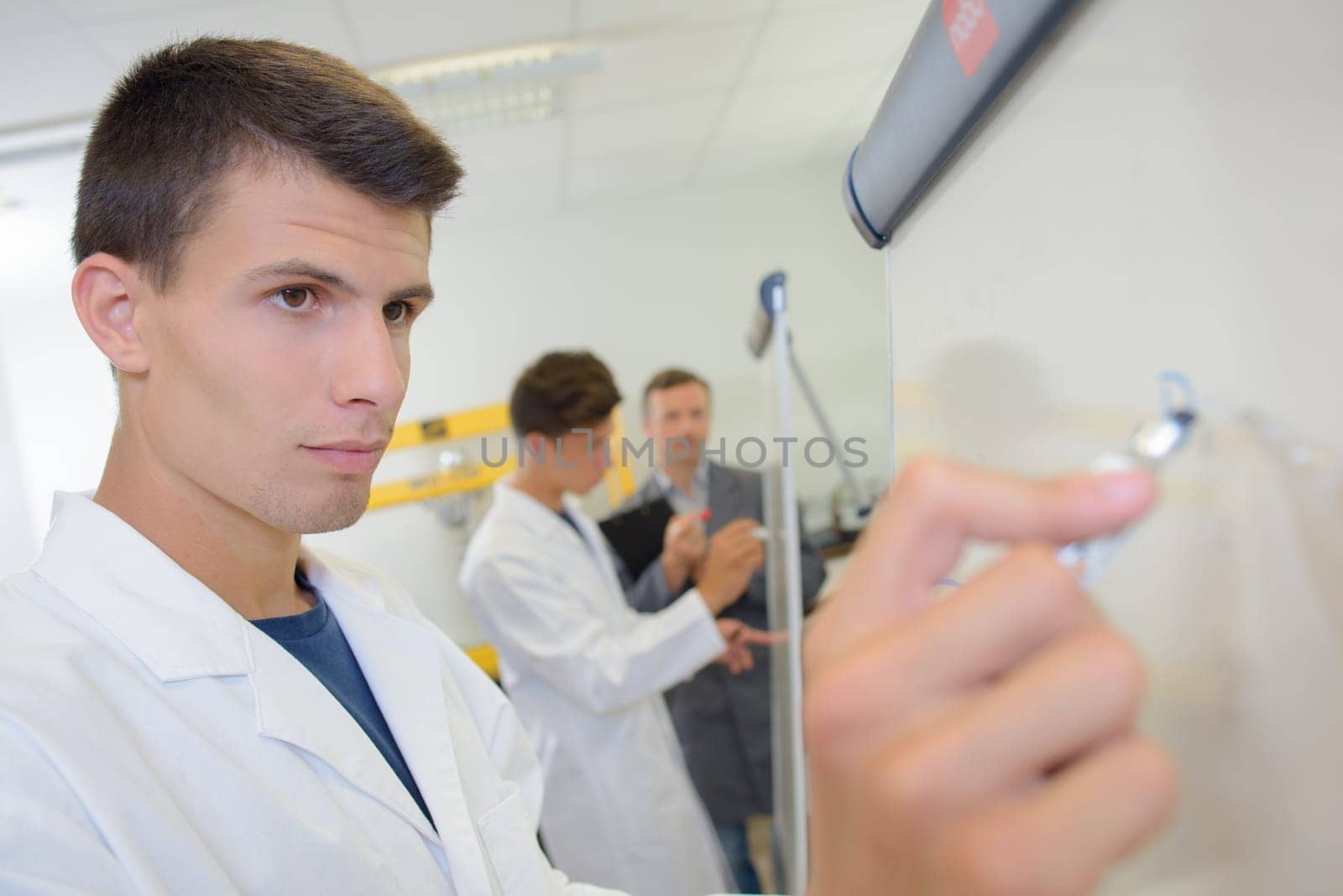 Young man writing on whiteboard