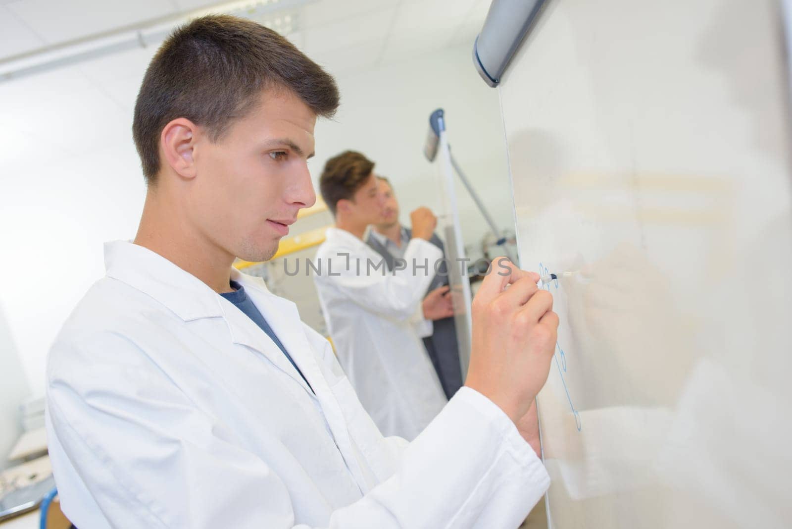 Young man writing on whiteboard