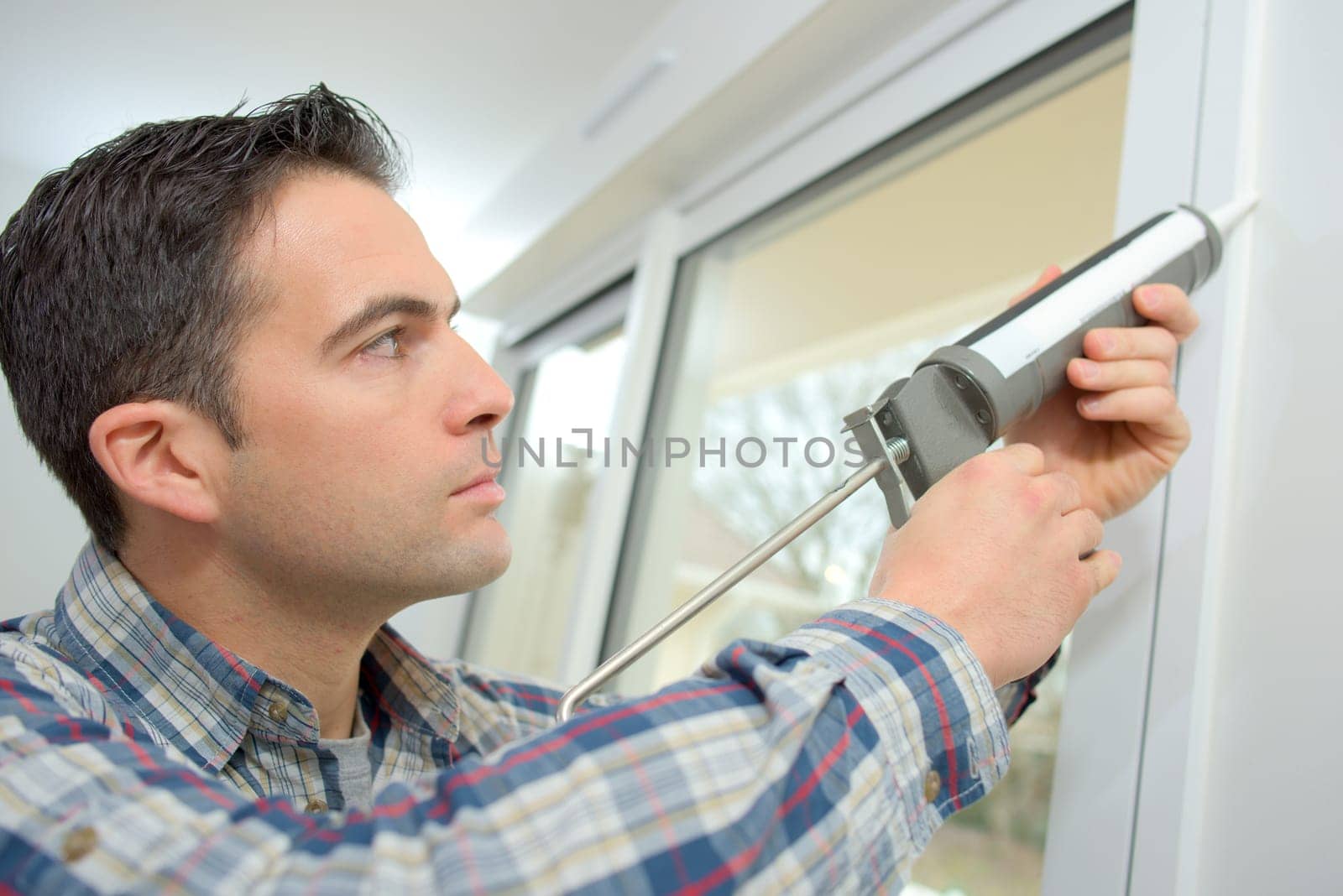 Handyman caulking a window
