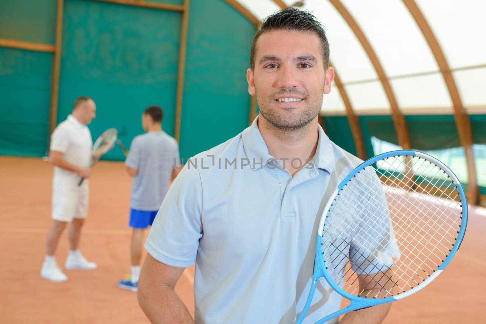 three men in the tennis court