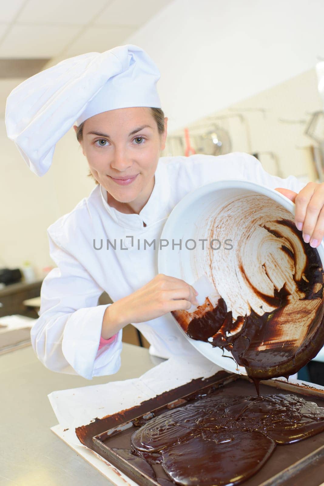 Chef scraping chocolate mixture into baking tray