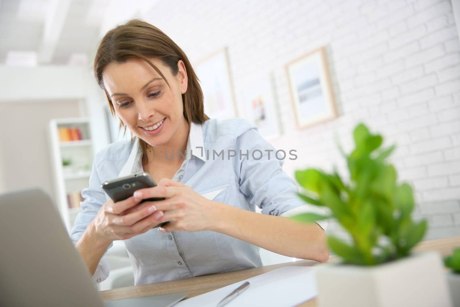 Woman in office talking on mobile phone