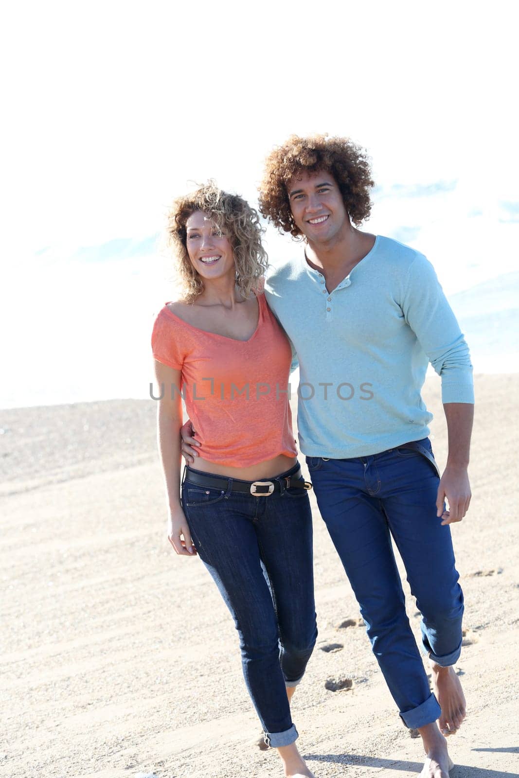 Smiling couple walking on the beach