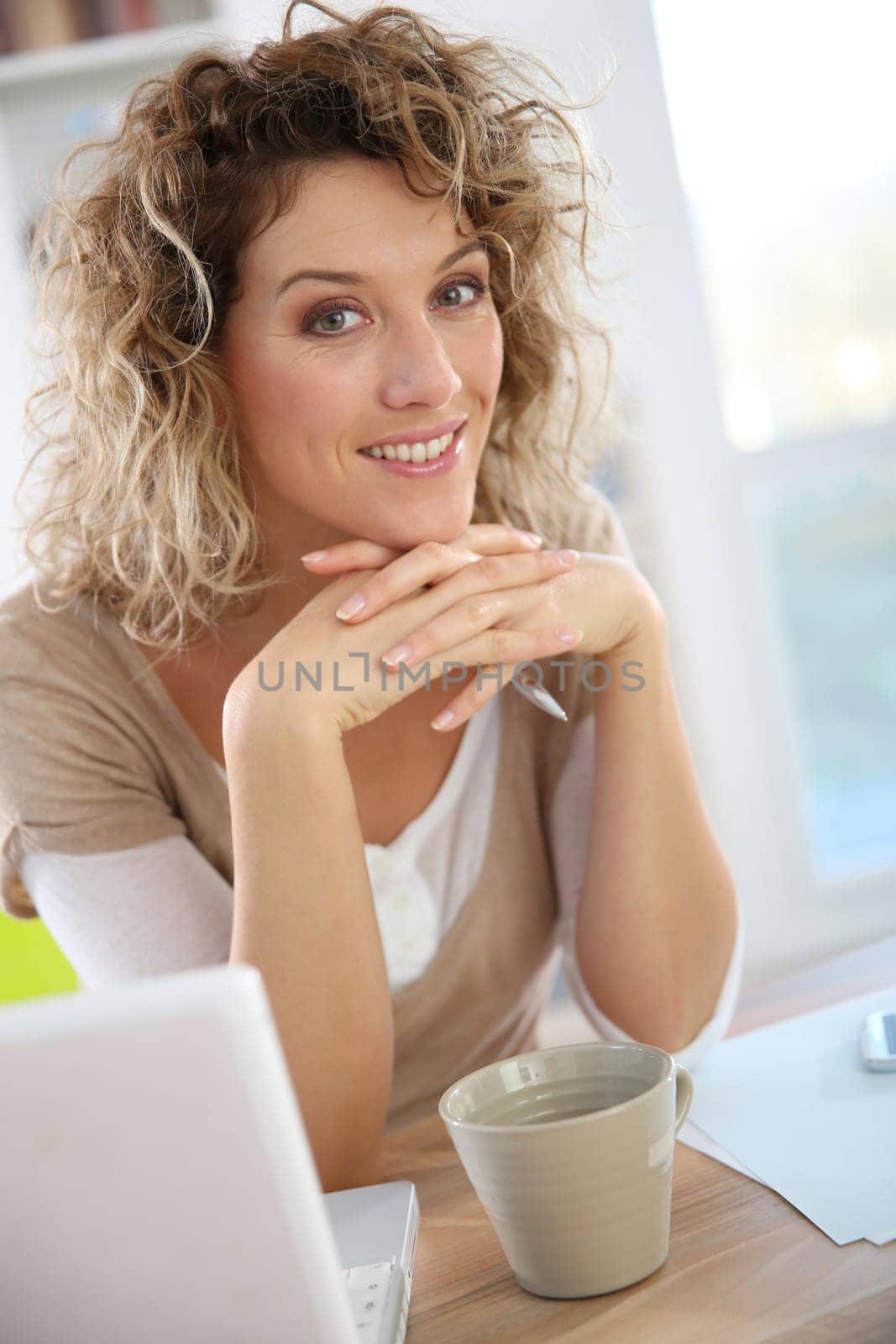 Smiling woman sitting in front of laptop computer