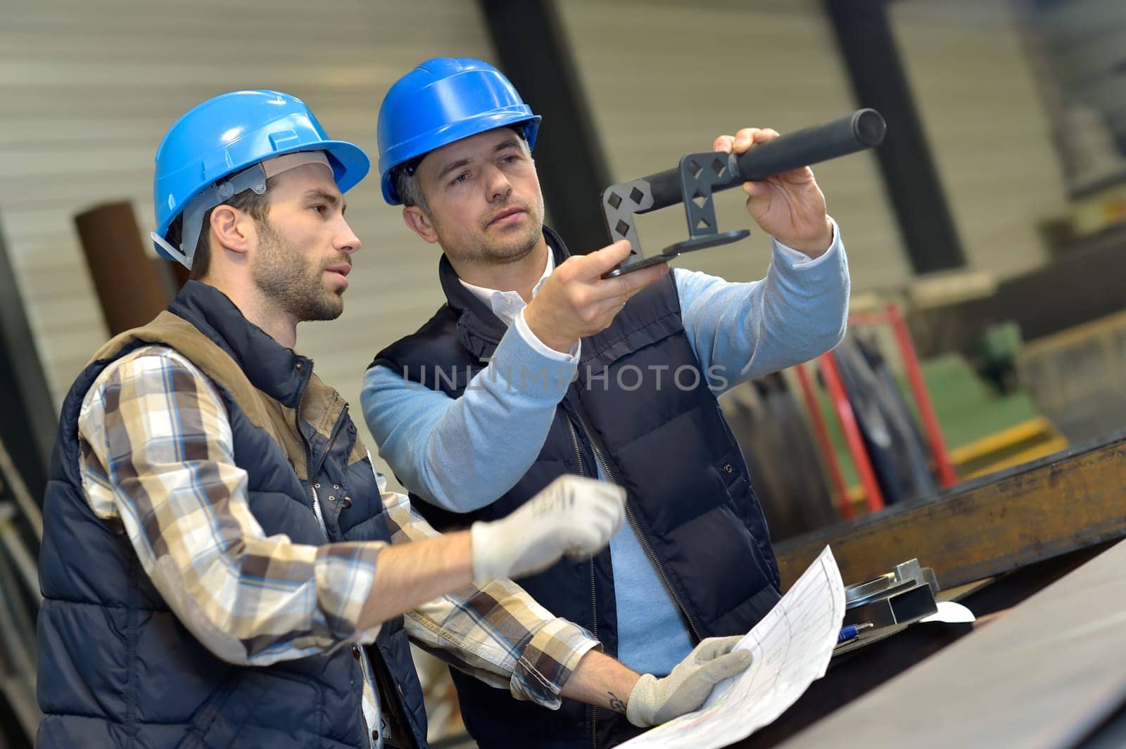 Engineer with mechanical worker checking on production