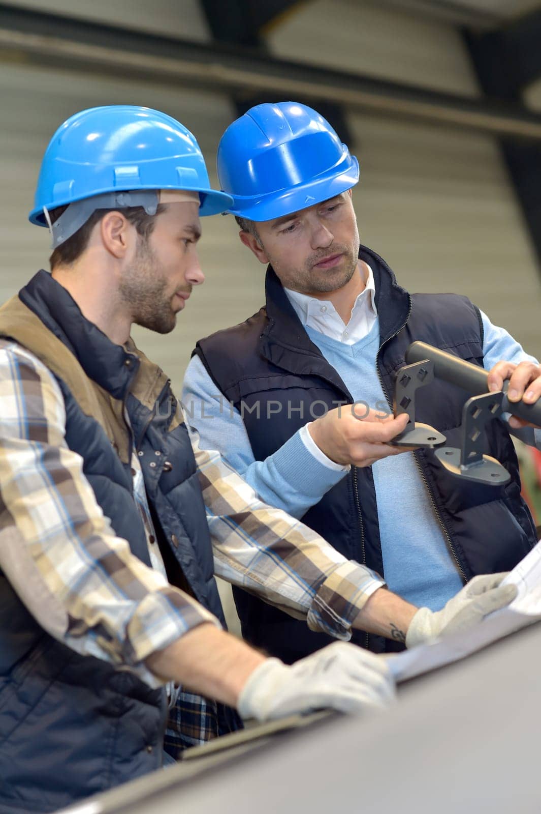 Engineer with mechanical worker checking on production