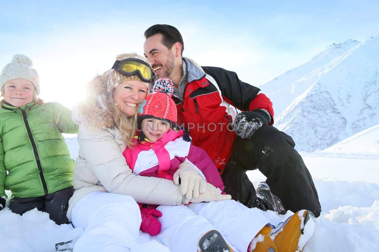Cheerful family sitting in snow