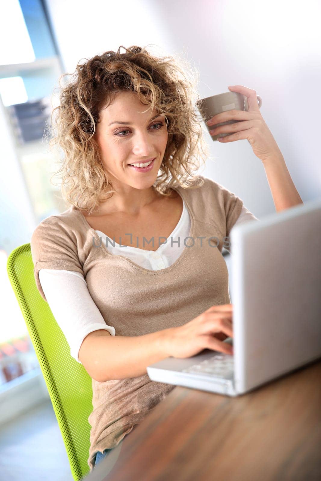 Smiling woman sitting in front of laptop computer