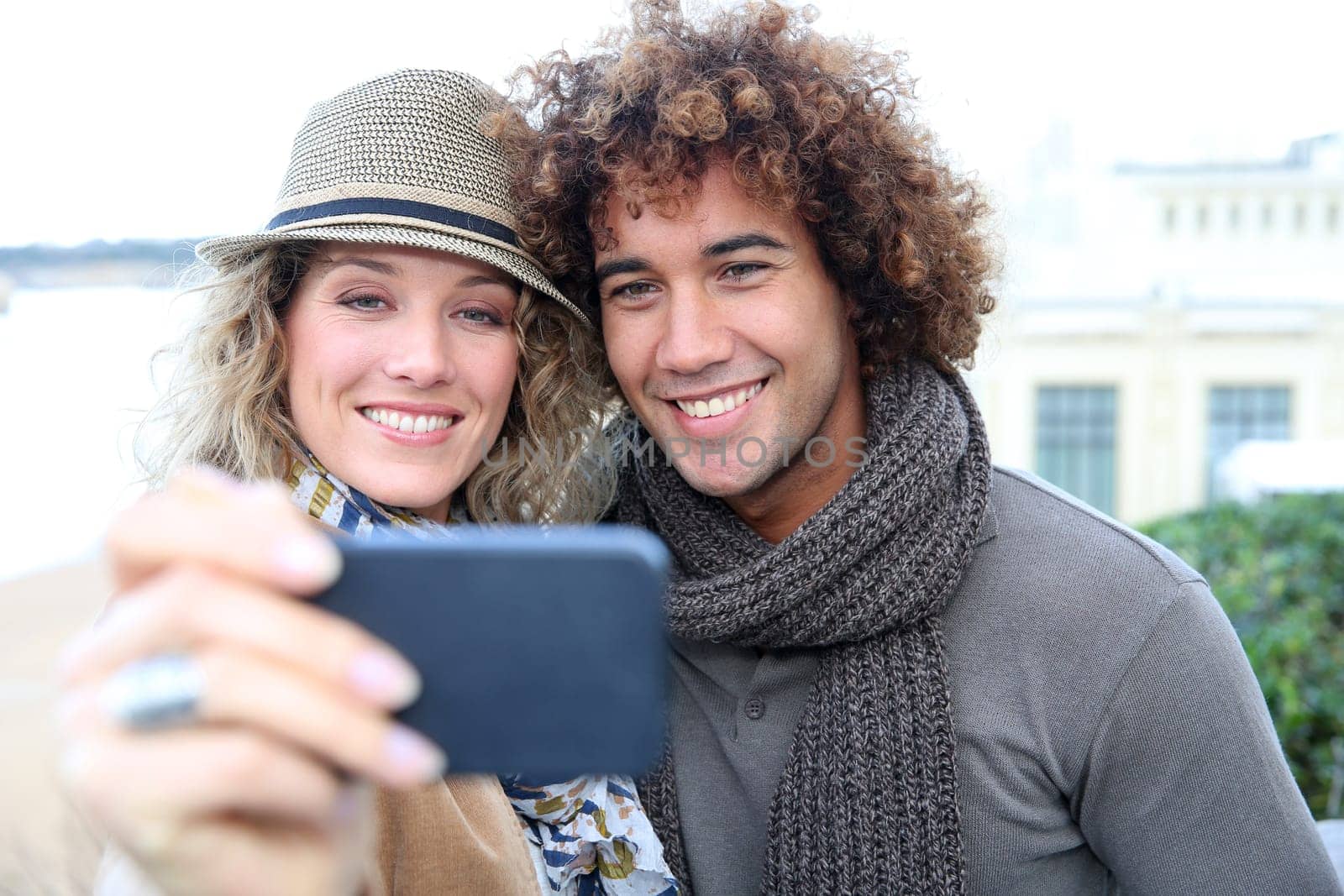 Cheerful couple taking picture with smartphone