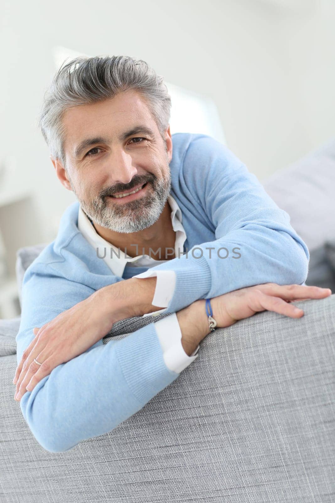 45-year-old man relaxing in sofa at home