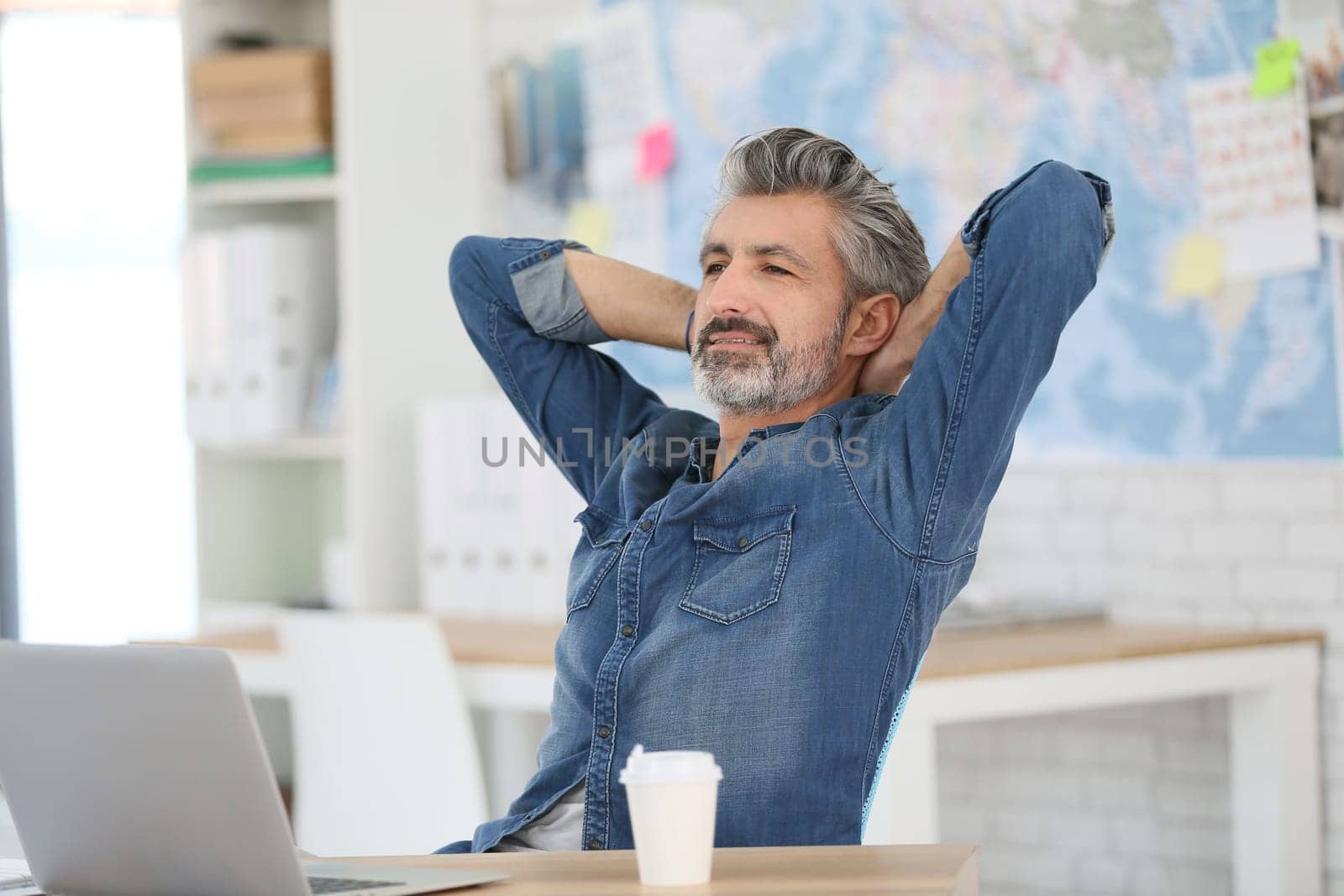 Mature man relaxing in front of laptop in class