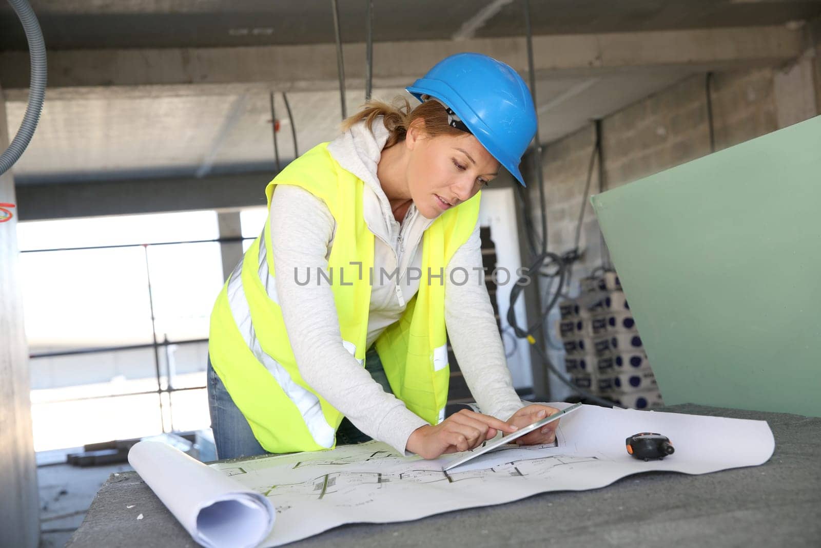 Woman architect on building site using tablet