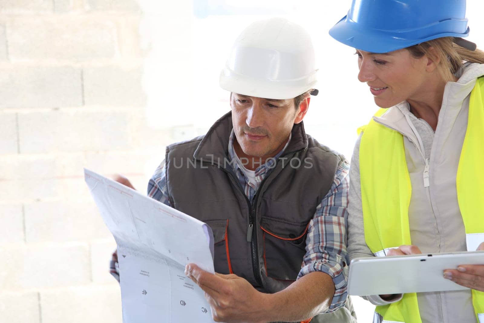 Engineers on building site checking plans