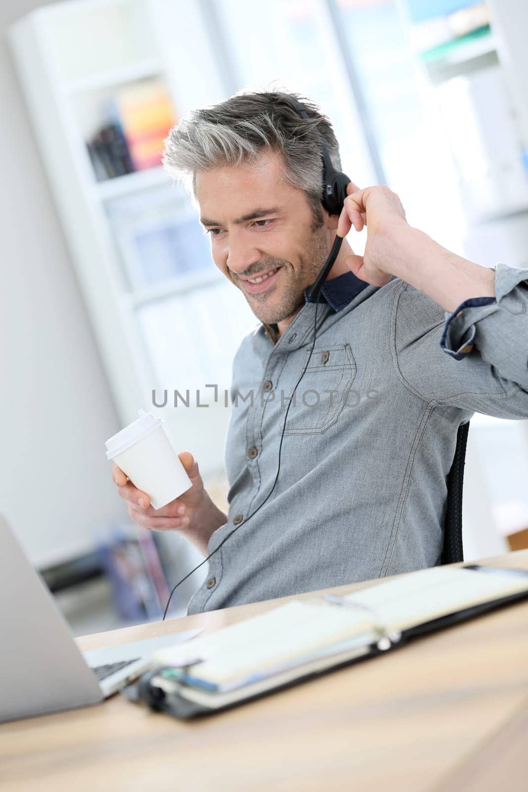 Mature man teleworking from home with laptop