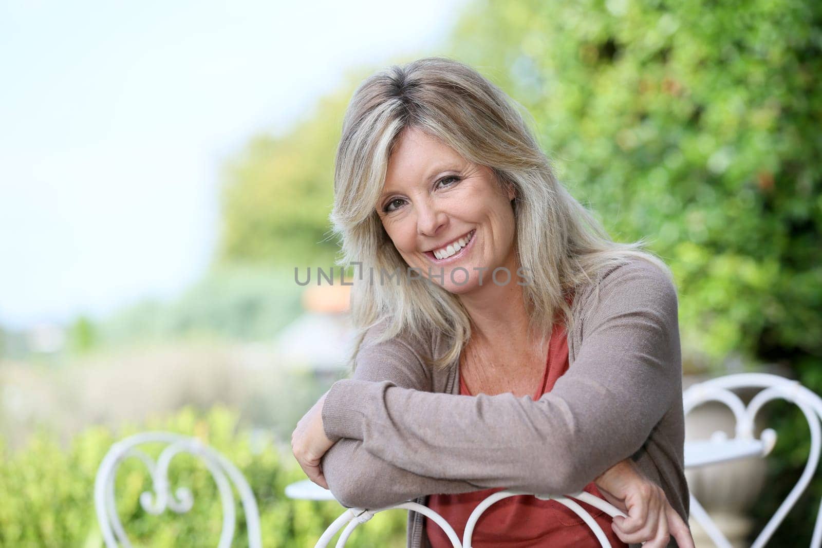Portrait of smiling mature blond woman in garden