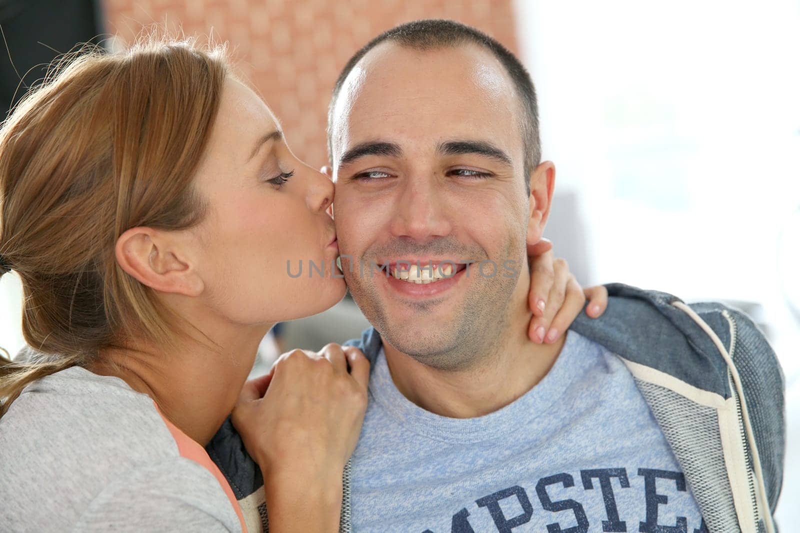 Girl kissing boyfriend on cheek